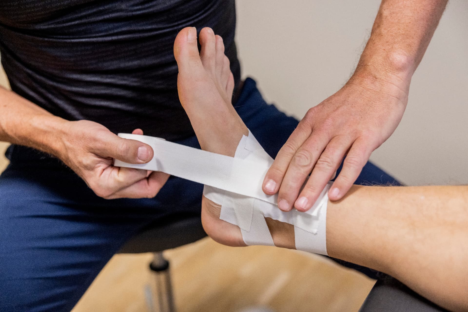 Fysioterapeut taper en patients ankel